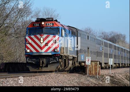 Geneva, Illinois, USA. A Metra locomotive pulling its commuter train from Chicago as it nears arrival at the local commuter station. Stock Photo
