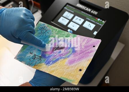 Bruchsal, Germany. 10th Jan, 2023. A sample is taken from a child's painting with a so-called swab at Bruchsal Prison (JVA). The painting, whose paper is impregnated with synthetic cannabinoid, comes from prisoner mail and was intended for an inmate. By means of an ion scanner (in the background), which can detect drugs, this was determined. (to dpa 'Drug scanners' in prisons strike about 150 times') Credit: Uli Deck/dpa/Alamy Live News Stock Photo