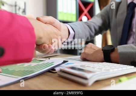 Close-up of two business people shaking hands at office table. Stock Photo