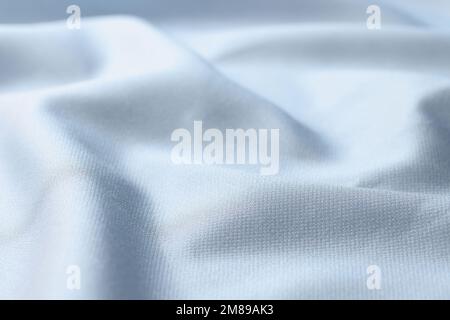 Waved light blue silk fabric background. Close up of satin textile. Stock Photo