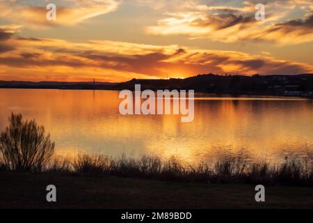 Sunset over Inks Lake State Park Burnet Texas, USA. The golden light reflects off of the sky and the water at the end of a perfect day. Stock Photo