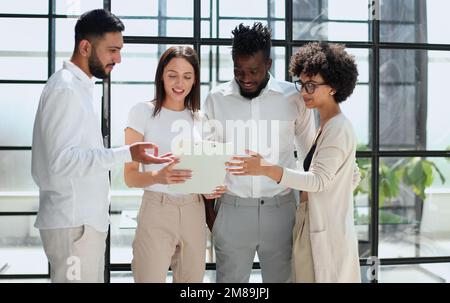 Employees working at computer together, discussing content Stock Photo