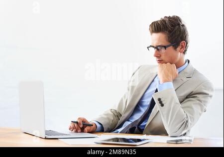 Project management takes concentration. A handsome young businessman focused on his laptop. Stock Photo