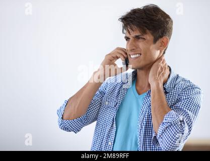 Not an easy call to make...Handsome young ethnic man speaking on his cellphone and smiling. Stock Photo