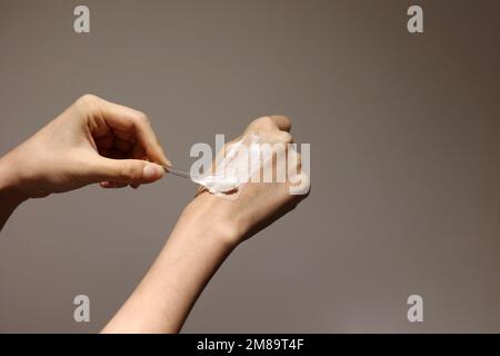 Applying cosmetic cream on the hands with spatula Stock Photo