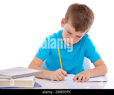 Young boy, writing and learning homework at desk for school, education and student knowledge. Paper, working and child with books for study, creative Stock Photo