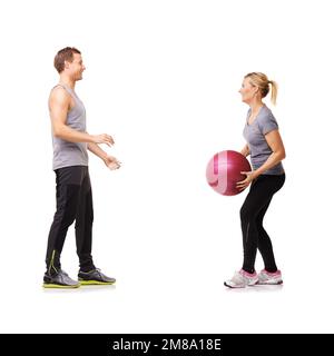 Helping him tone up. A man and woman exercising by throwing a medicine ball to each other. Stock Photo