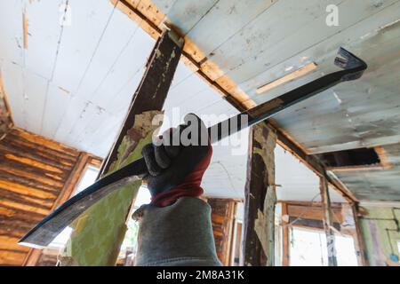 Nail puller in male hand, house demolition is in progress Stock Photo