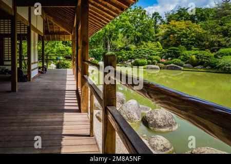 The wooden traditional japanese building and pond of the japanese garden in Compans Caffarelli, Toulouse (France) Stock Photo