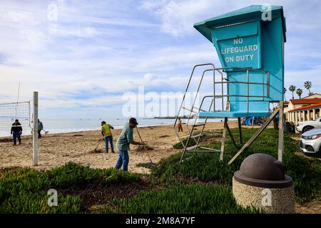 Santa Barbara, California, U.S.A. 12th Jan, 2023. Santa Barbara Parks and Recreation workers clean up the sand on East Beach in front of a Life guard shack with sign that reads, 'No Lifeguard On Duty'', a Volleyball net and a trash can after the severe storms littered the area with mud and debris. (Credit Image: © Amy Katz/ZUMA Press Wire) EDITORIAL USAGE ONLY! Not for Commercial USAGE! Stock Photo