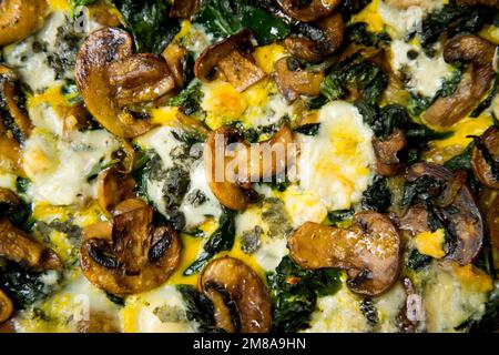 Spinach mushrooms French quiche. In gastronomy, a quiche is a type of savory tart derived from the French quiche lorraine. Stock Photo