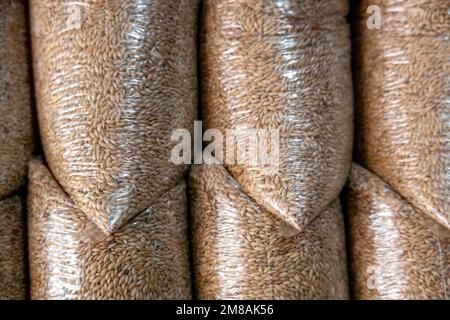 A pile of plastic bags filled with Canary grass (Phalaris canariensis) seeds Stock Photo
