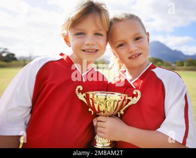 We did it. Portrait of a two young girls holding a sports trophy. Stock Photo