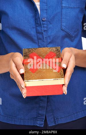 Unwrap it this Christmas. a woman holding a gift box. Stock Photo