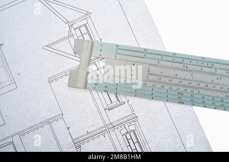 Architects drawings with a slide ruler. An old fashioned way to make calculations. Drawing to scale, survey and planning. Stock Photo