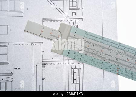 Architects drawings with a slide ruler. An old fashioned way to make calculations. Drawing to scale, survey and planning. Stock Photo