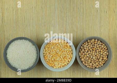 Rice, chickpeas and peas in bowls on a straw background. Vegetarian organic product. Vintage view. Top view. Copy space. Stock Photo