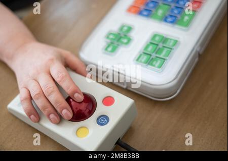 Woman with cerebral palsy works on a specialized computer mouse. Stock Photo