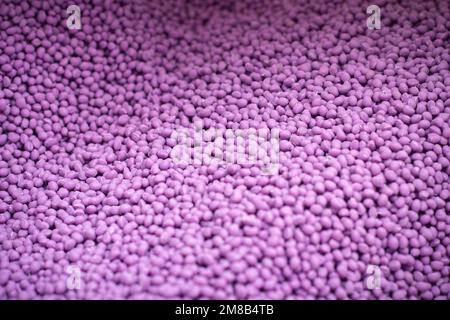 biodegradable plastic granules texture, plastic polymer dye pellets color clear purple Stock Photo