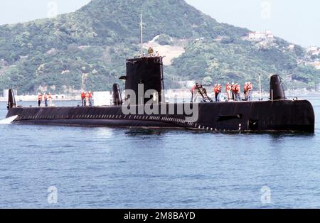 Crew members stand atop the attack submarine USS DARTER (SS 576) as the ...