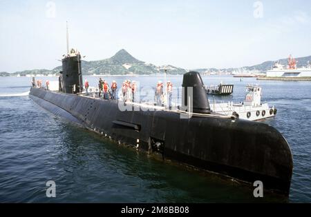 Crew members stand atop the attack submarine USS DARTER (SS 576) as the ...