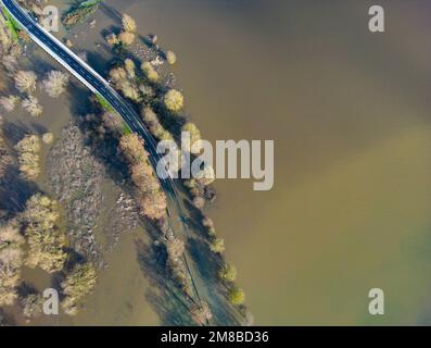 Heuchelheim, Germany. 13th Jan, 2023. A country road near Heuchelheim in Hesse is flooded after days of rainfall (aerial photo taken with a drone). With further rainfall, more rivers and streams could burst their banks. Credit: Boris Roessler/dpa/Alamy Live News Stock Photo