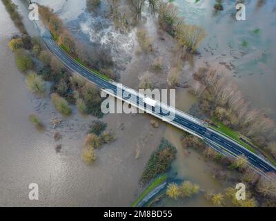 Heuchelheim, Germany. 13th Jan, 2023. A truck drives over a flooded country road near Heuchelheim in Hesse (aerial photo taken with a drone). With further precipitation, more rivers and streams could burst their banks. Credit: Boris Roessler/dpa/Alamy Live News Stock Photo