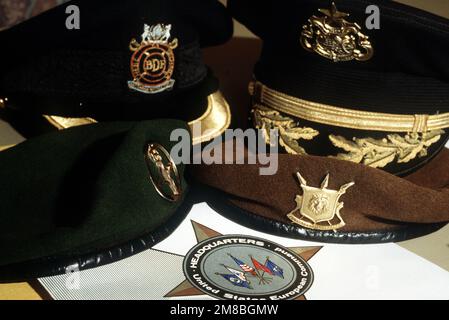 Hats belonging to some of the participants in the U.S. African Medical Symposium sit on a table near a folder bearing the emblem of the U.S. European Command, which is sponsoring the symposium. Medical personnel from the U.S., Botswana, Burundi, Chad, Ghana, Liberia, Niger, Nigeria, Senegal, Uganda and Zaire are attending the three-day meeting. Base: Freudenstadt Country: Federal Republic Of Germany (FRG) Stock Photo