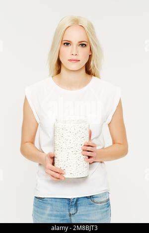 Portrait, pills and medicine with a model woman holding a jar in studio on a gray background for healthcare. Medical, supplements and medication with Stock Photo