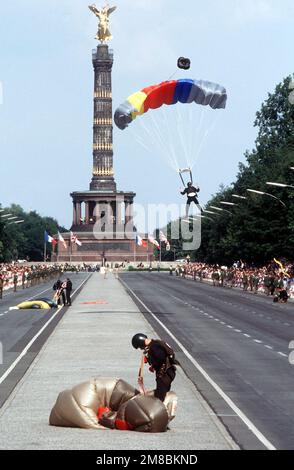 Members of the Combined Allied Parachute Demonstration Team land on 17th of June Street during the annual Allied Forces Day parade. The 'Siegessaulte' (Victory Column) is in the background. Base: West Berlin Country: Deutschland / Germany (DEU) Stock Photo