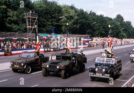 A combined French, American and British motorized color guard drives along 17th of June Street during the annual Allied Forces Day parade. The vehicles are, from left: a French Peugeot P-4 light vehicle, an American M998 High-Mobility Multipurpose Wheeled Vehicle (HMMWV) and a British Land Rover. Base: West Berlin Country: Deutschland / Germany (DEU) Stock Photo