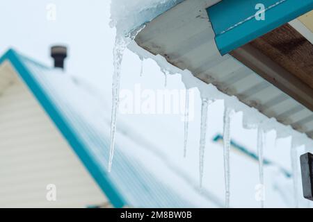 icicles hang on the roof. Danger in winter Stock Photo