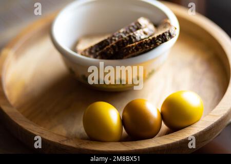 Easter breakfast of colored eggs and grain bread on a beautiful wooden tray Stock Photo