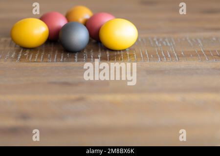 Bright Easter eggs lie on a beautiful wooden table Stock Photo