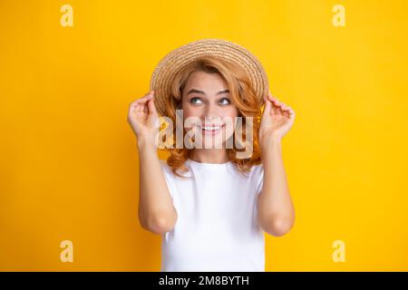 Portrait of funny woman in stylish straw hat on yellow background. Stock Photo