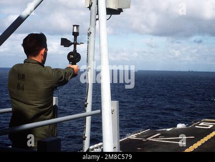 An aerographer's mate uses a hand-held anemometer Wind Measuring Set AN/PMQ-3) to measure wind speed and direction on the deck of the amphibious assault ship USS PELELIU (LHA 5) during PACEX '89. Subject Operation/Series: PACEX '89 Base: USS Peleliu (LHA 5) Stock Photo
