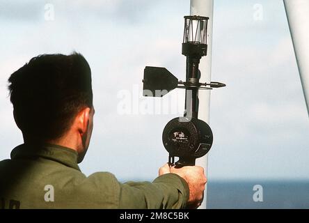 An aerographer's mate uses a hand-held anemometer (Wind Measuring Set AN/PMQ-3) to measure wind speed and direction on the deck of the amphibious assault ship USS PELELIU (LHA-5) during PACEX '89. Subject Operation/Series: PACEX '89 Country: Unknown Stock Photo
