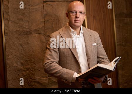 Pleasant man holds a large open book in his hands Stock Photo