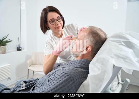 Doctor uses modern fillers for rejuvenating course for adult patient Stock Photo