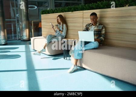 Two colleague sitting and working in office lobby Stock Photo