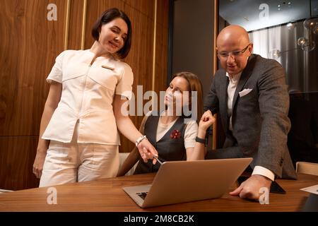 Woman in medical clothes points at the screen of laptop Stock Photo