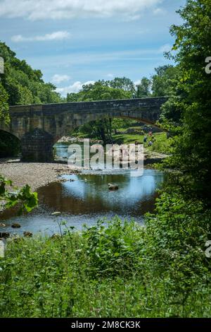 9th July 2022 - Kettlewell, UK: People in the River Wharfe during the summer heatwave of 2022 at Kettlewell, Upper Wharfedale, North Yorkshire, UK Stock Photo
