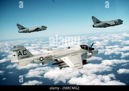 An air-to-air right side view of an Attack Squadron 75 (VA-75) KA-6D Intruder aircraft, foreground, and two Attack Squadron 72 (VA-72) A-7E Corsair II aircraft. The aircraft, stationed aboard the aircraft carrier USS JOHN F. KENNEDY (CV-67), are flying over the Atlantic coast while taking part in Exercise Fleet Ex '90. Subject Operation/Series: FLEET EX '90 Country: Atlantic Ocean (AOC) Stock Photo