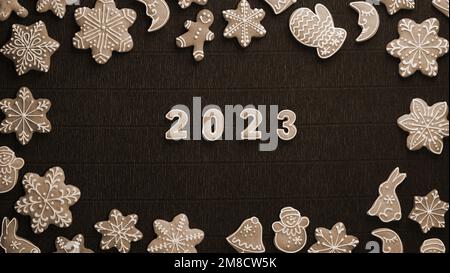Christmas Border of glazed cookies with date 2023 inside on a Dark background. View from above. Happy New Year. Stock Photo