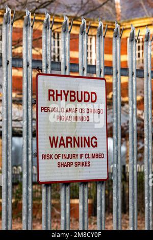 Whitchurch Mental Hospital, abandoned Grade II listed building left to decay. Security fence with spikes and warning notice. Stock Photo