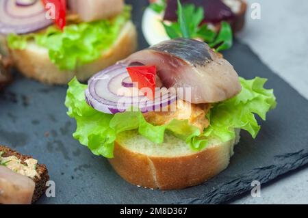 Appetizer with salted herring, pate, onion, egg, lettuce, tomato and beetroot. Scandinavian cuisine. Banner, menu, recipe place for text, top view. Bu Stock Photo