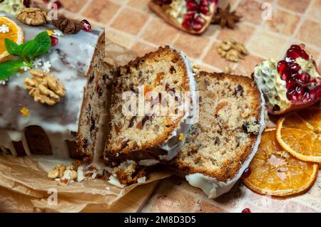 Christmas stollen with candied fruit and dried fruits on parchment. Stollen - traditional German bread eaten during the Christmas season. Stock Photo