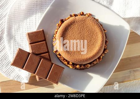 Top view of brown chocolate tart with nuts and caramel on the kitchen table background. Stock Photo