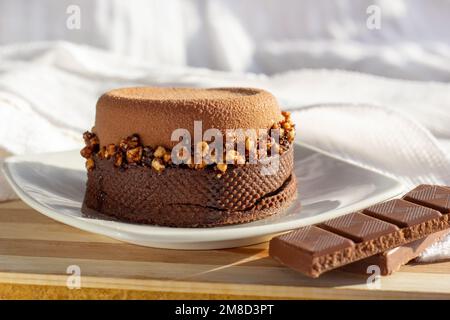 Brown chocolate tart with nuts and caramel on the kitchen table background. Stock Photo