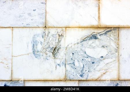 Blue and gray vintage marble ceramic tile textured background on the old building stone brick wall close up. Stock Photo